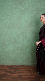 Red saree gives a dramatic and elegant appeal. Styled with a shimmer blouse and traditional jewelry, the saree stands out against a textured green background, making it perfect for festive and evening wear fashion shoots.